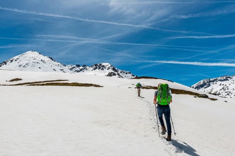 Two hikers walk over snowfield