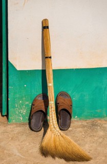 Broom and shoes against wall