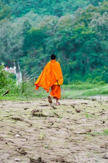 Buddhist monk running along banks of Mekong