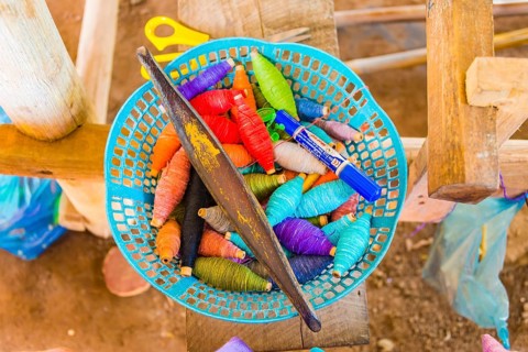 Basket with colorful yarn and needle for weaving