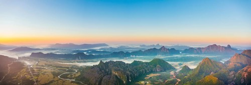 Panorama of karst mountains with mist at sunrise