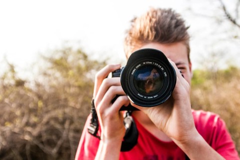 Young man photographing with a SLR