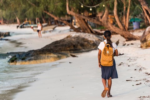 Local girls walking to school on idyllic sandy beach at Koh Tui Beach