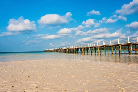 Pier on beach with turquoise water at Saracen Bay on Koh Rong Sanloem island