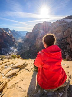 Young woman looking into the distance from Angels Landing to Zion Canyon