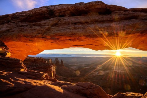 View through arch Mesa Arch at sunrise with sunstar