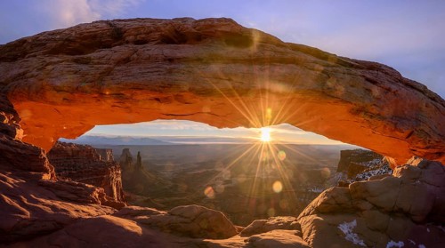 View through arch Mesa Arch at sunrise with sunstar