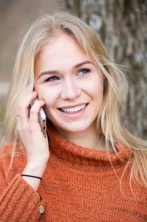 Blonde young woman phoning with a mobile