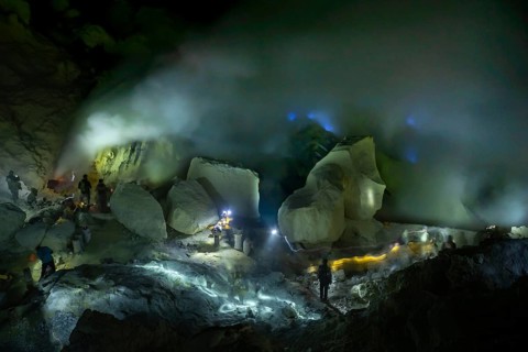 Workers in toxic sulfur mining in sulfur mine at night