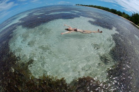 A young woman lying in the water on her back