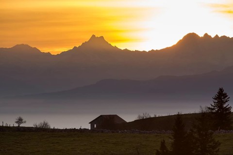 A cabin on the Creux du Van at sunrise overlooking the mountains Schreckhorn