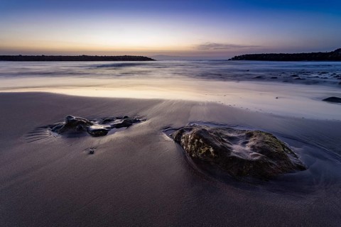 Beach with stones embedded in sand