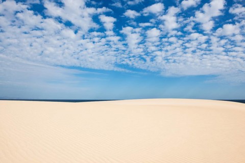Dunes against blue sea