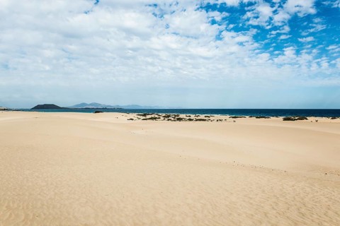 Dunes against blue sea
