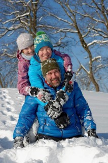 Father and his children rollicking in the snow