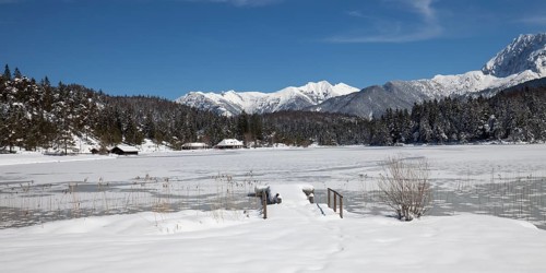 Frozen lake Lautersee in front of Karwendel Mountains