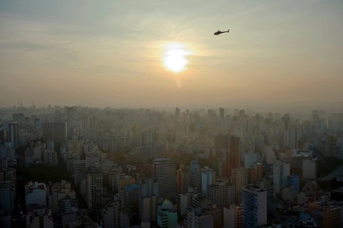 Helicopter above a cityscape with skyscrapers at sunset