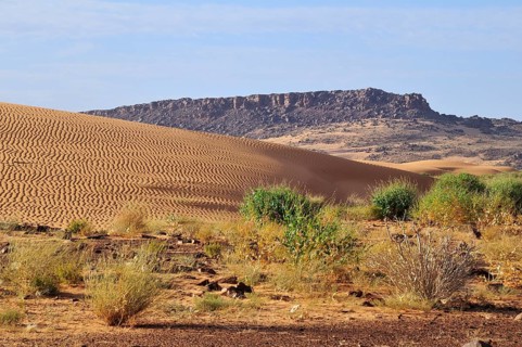 Desert landscape with sand dune and rocky hills