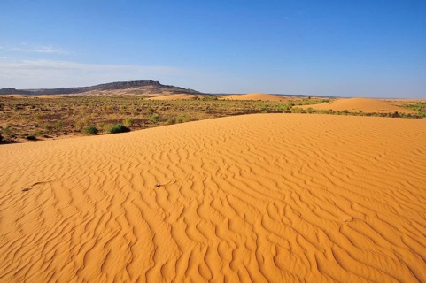 Desert landscape with sand dune and rocky hills