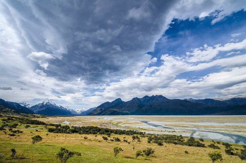 Grassland in front of the wide riverbed of the Tasman River