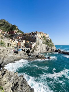 Rocky coast and view to the village of Manarola