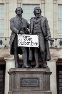 Goethe and Schiller monument with sign Wir bleiben hier or We stay here