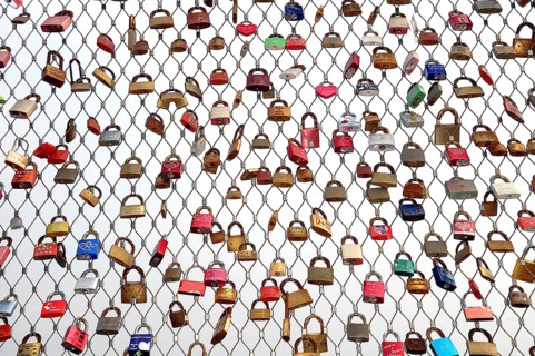 Love locks hanging on metal grid