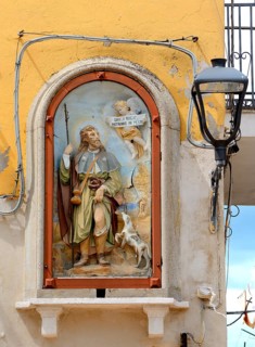 Painting of patron saint on a wall with power cables