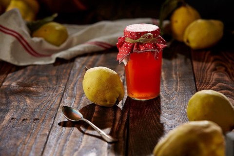 Quince jelly and fruit on wooden table