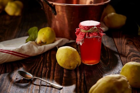 Quince jelly and fruit on wooden table