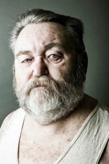 Obese senior with a full beard and in his undershirt