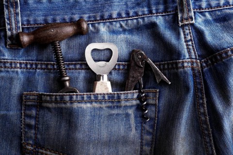 Old corkscrew and bottle openers in the pocket of jeans