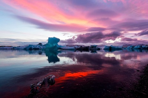 Blue iceberg in sunset