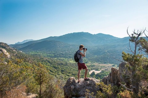 Young man doing landscape photography of the mountainous views in Sartene