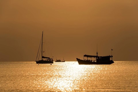 Two boats in sea at sunset