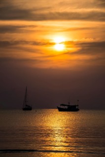 Two boats in sea at sunset
