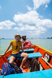 Young man sitting in longtail boat