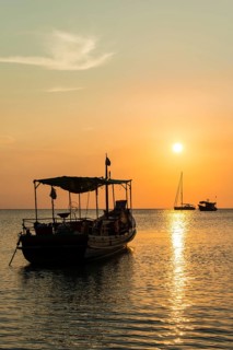 Fishing boat in sea at sunset
