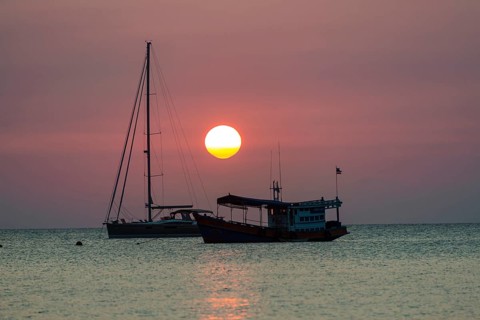 Two boats in sea at sunset
