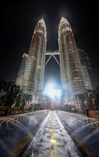 Fountain in front of illuminated Petronas Twin Towers at night