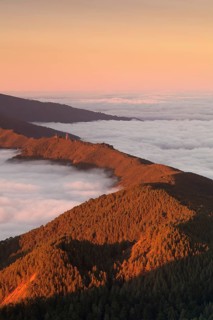 Mountain Cumbre Nueva above clouds at sunset