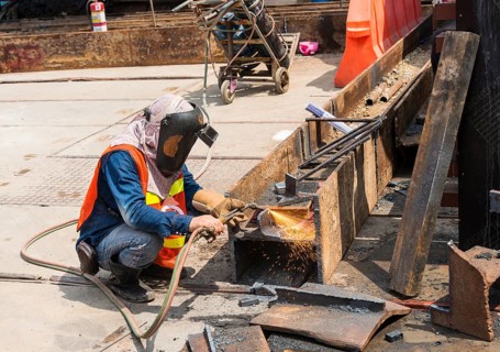 Construction worker welding a steel beam on a construction site