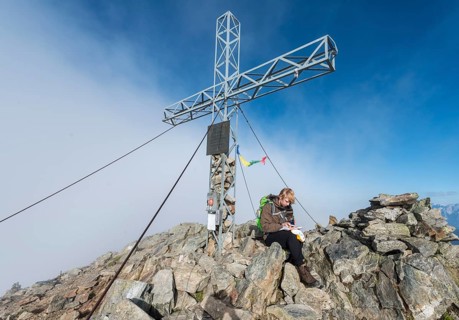 Hiker writing in the logbook at the summit
