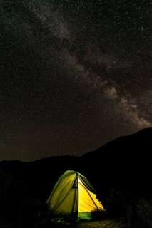 Tent on a campsite with starry sky above and Milky Way
