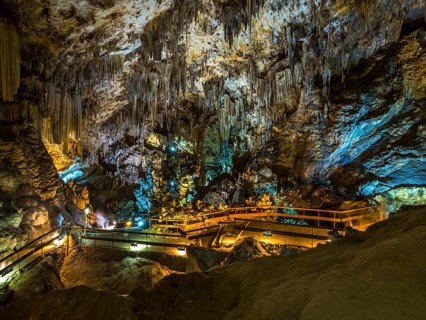 Stalactites in the colorfully lit cave Cuevas de Nerja