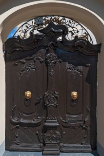 Decorative gate with two gold lion heads as door knockers