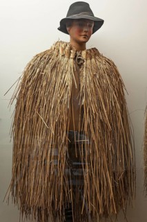 Figure of a shepherd boy with Franconian weather protection made from straw in a showcase