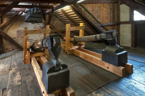 Old blacksmith's hammers and above an old bellow of 1875