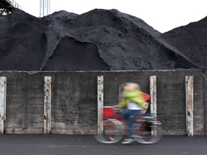 Cyclist riding past coal ash heap