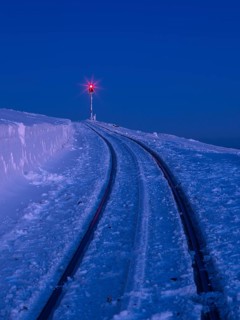Red signal light on snow-covered tracks of the Brocken railway